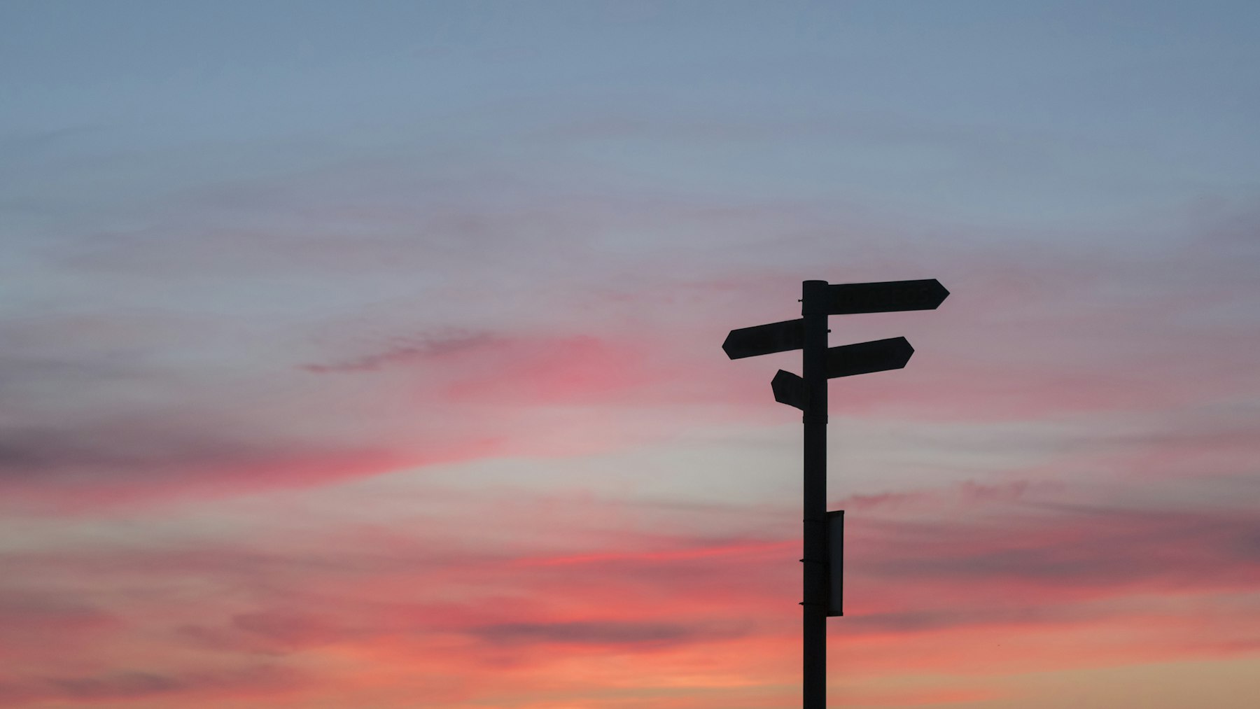 Wegweiser vor Abendhimmel